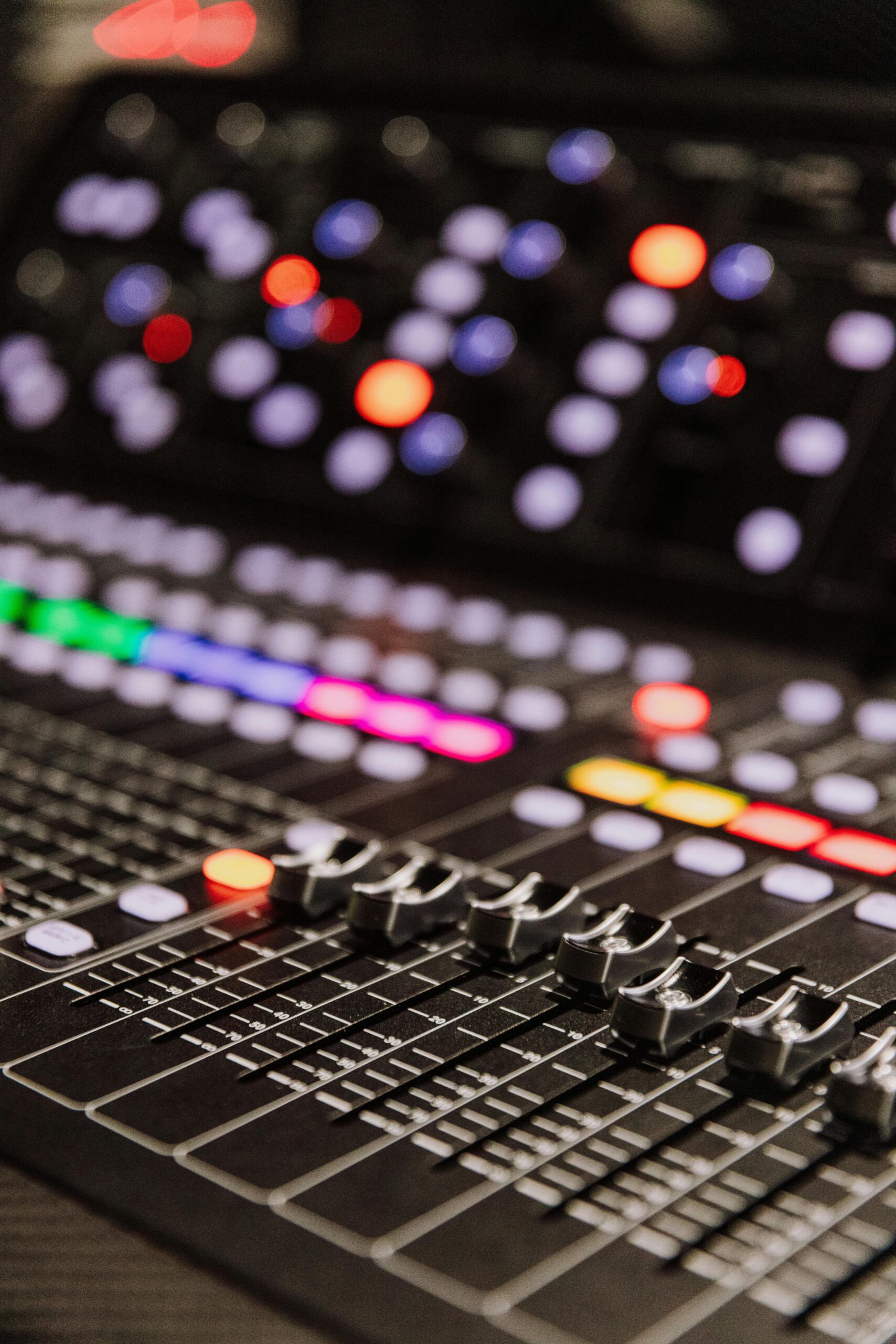 Close-up of a professional sound mixer with colorful LED indicators, ideal for music production.